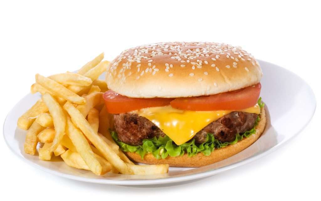 hamburger with vegetables and fries on white background
